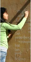 female student writing on wall covered with craft paper